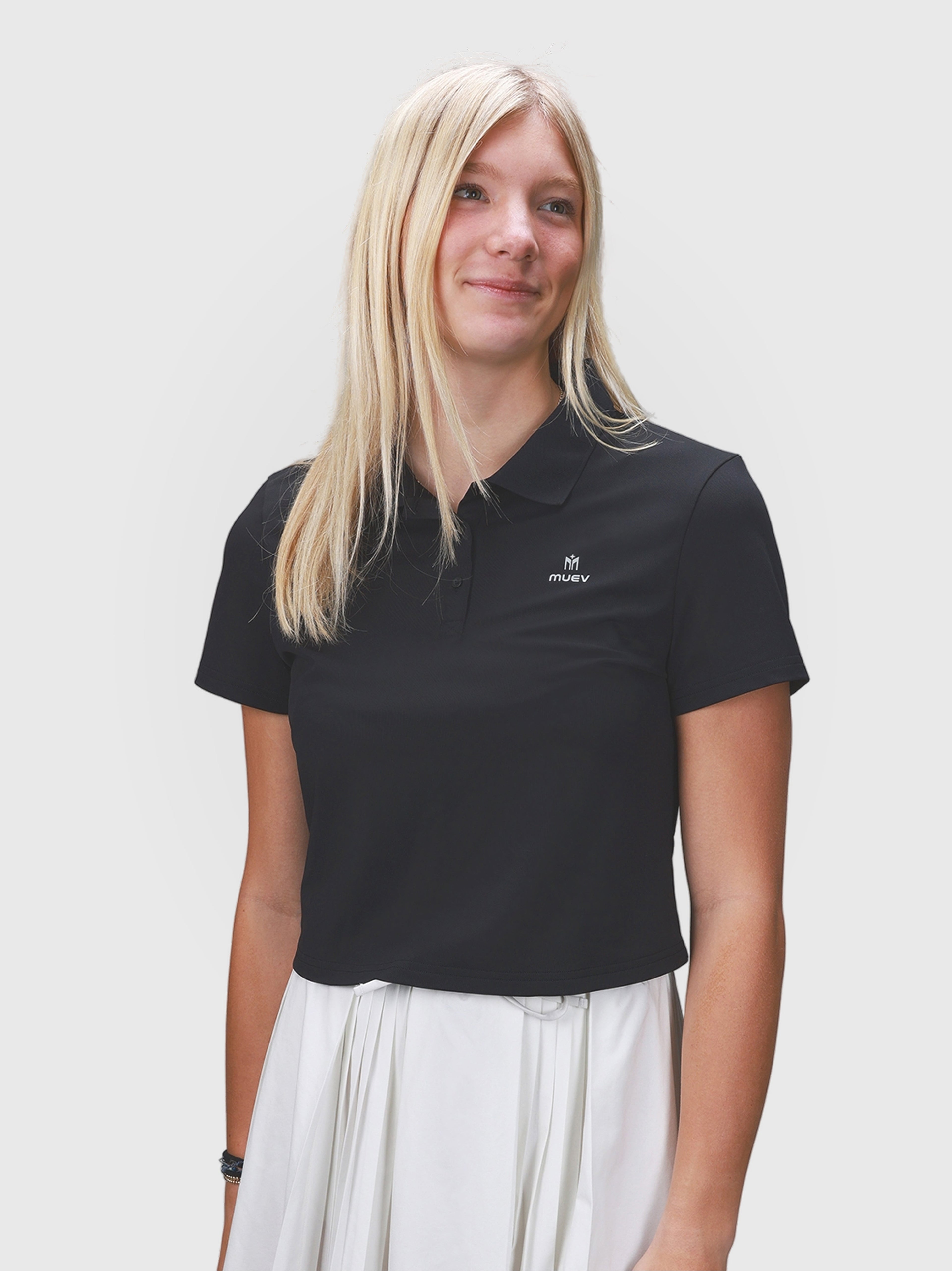 Woman wearing black Open Back Polo by MUEV designed as padel and pickleball clothing with a classic collar and short sleeves