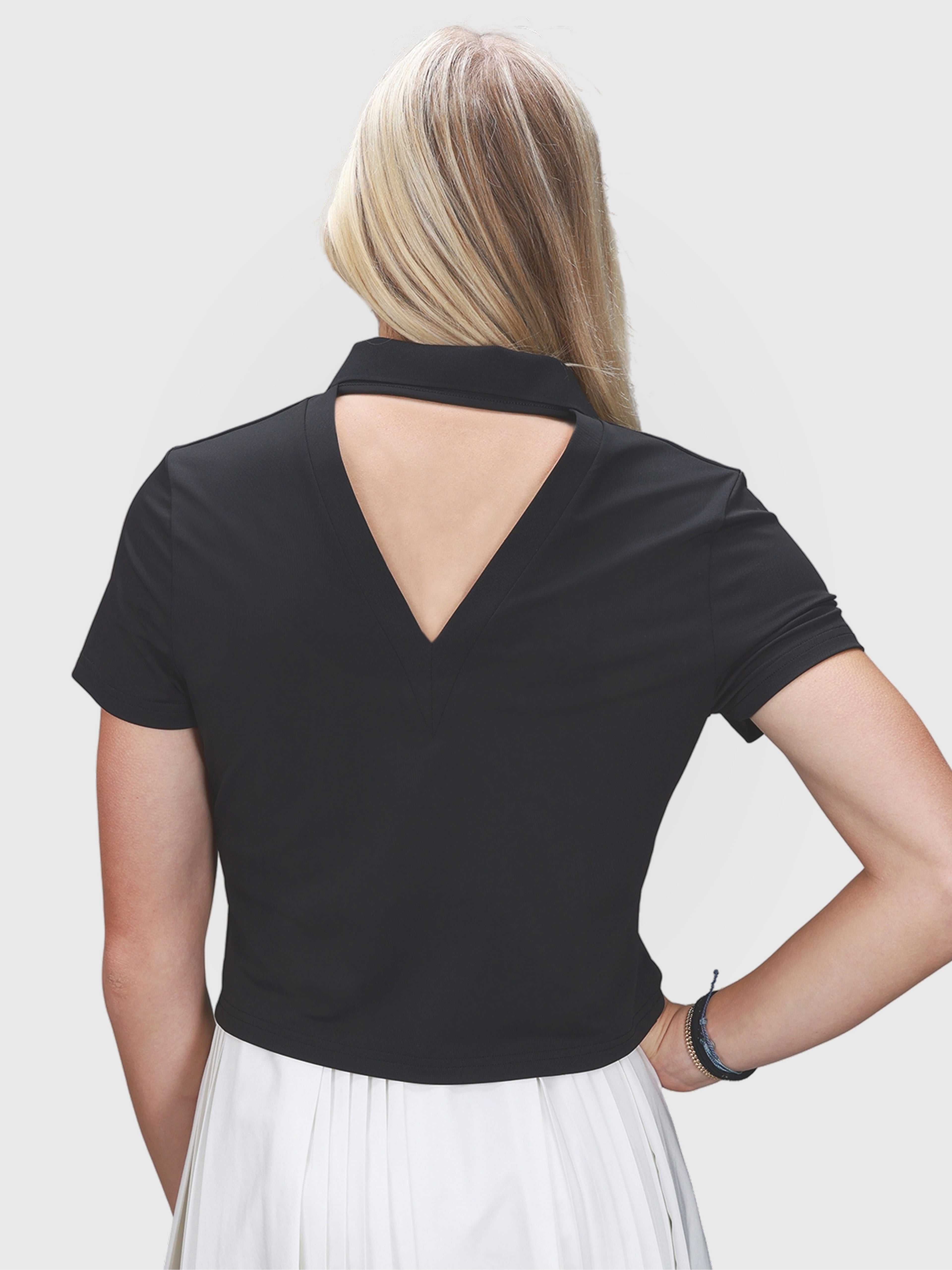 Back view of black Open Back Polo by MUEV with triangular cutout, designed for padel and pickleball clothing