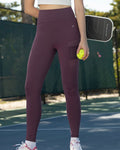 Woman in athletic wear holding a tennis ball on a tennis court