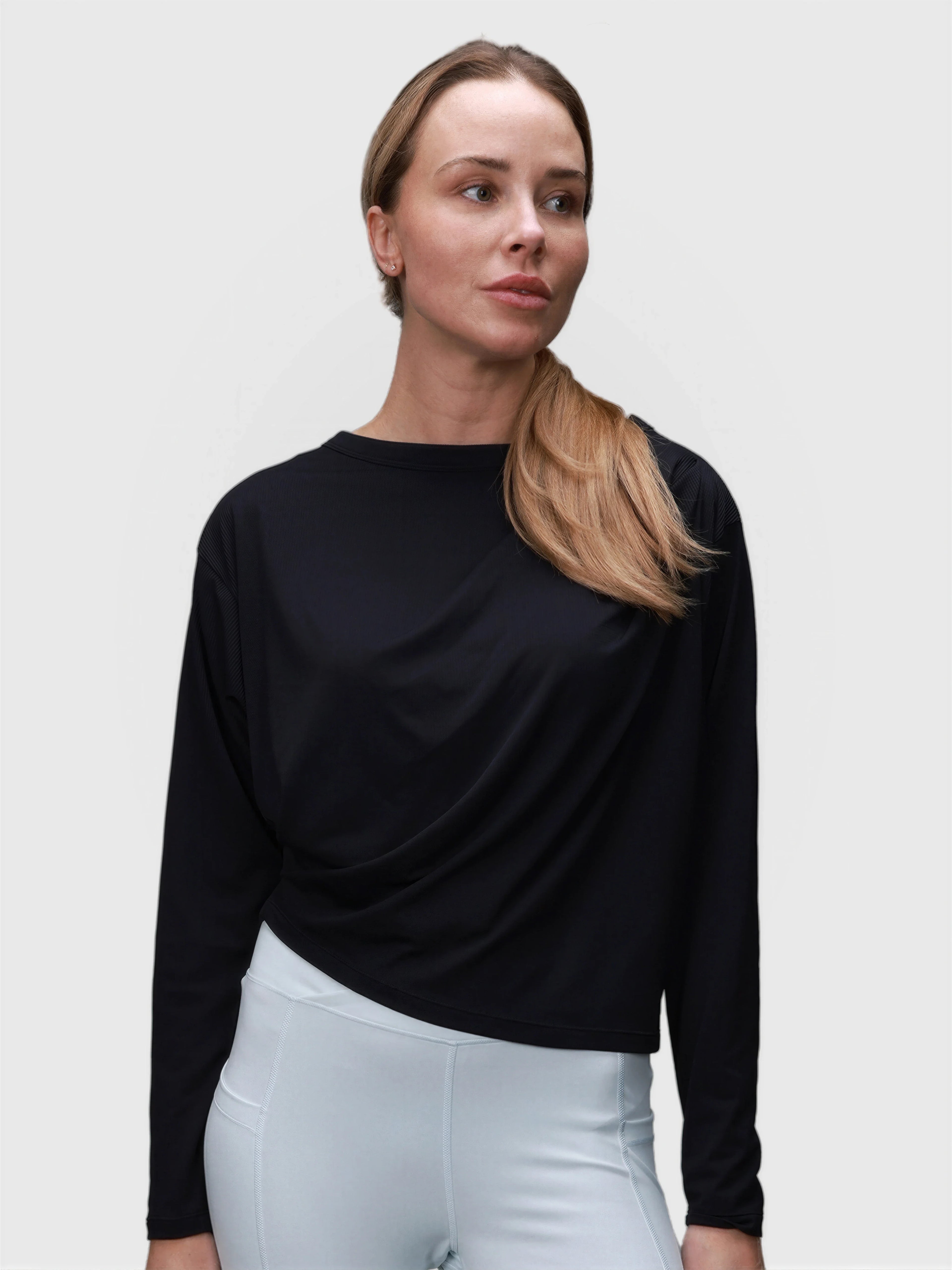 Woman wearing black Airy Twist Long Sleeve by MUEV styled for pickleball and padel clothing