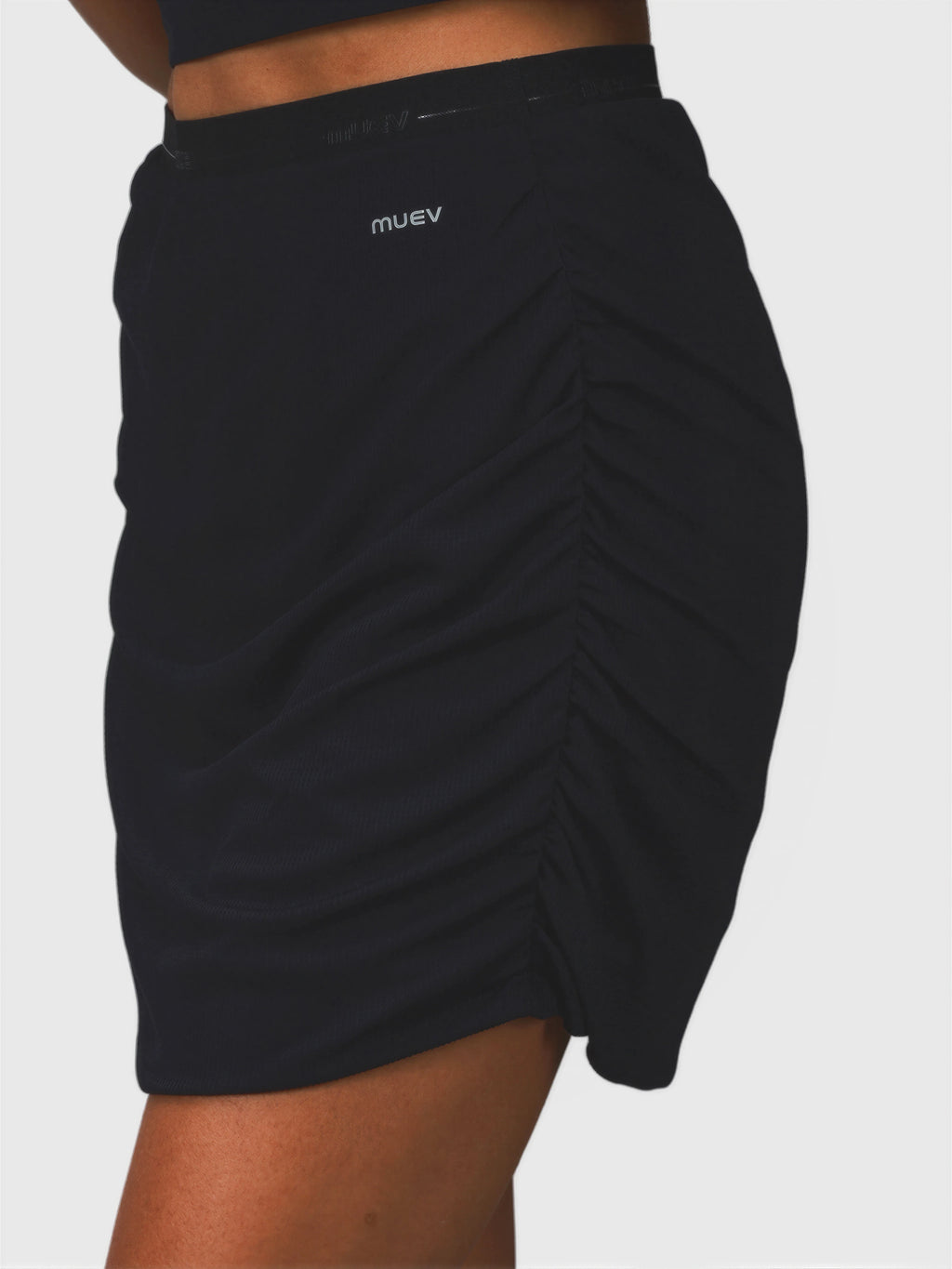 Close-up side view of black Airy Twist Skort by MUEV featuring ruched detail for padel and pickleball clothing