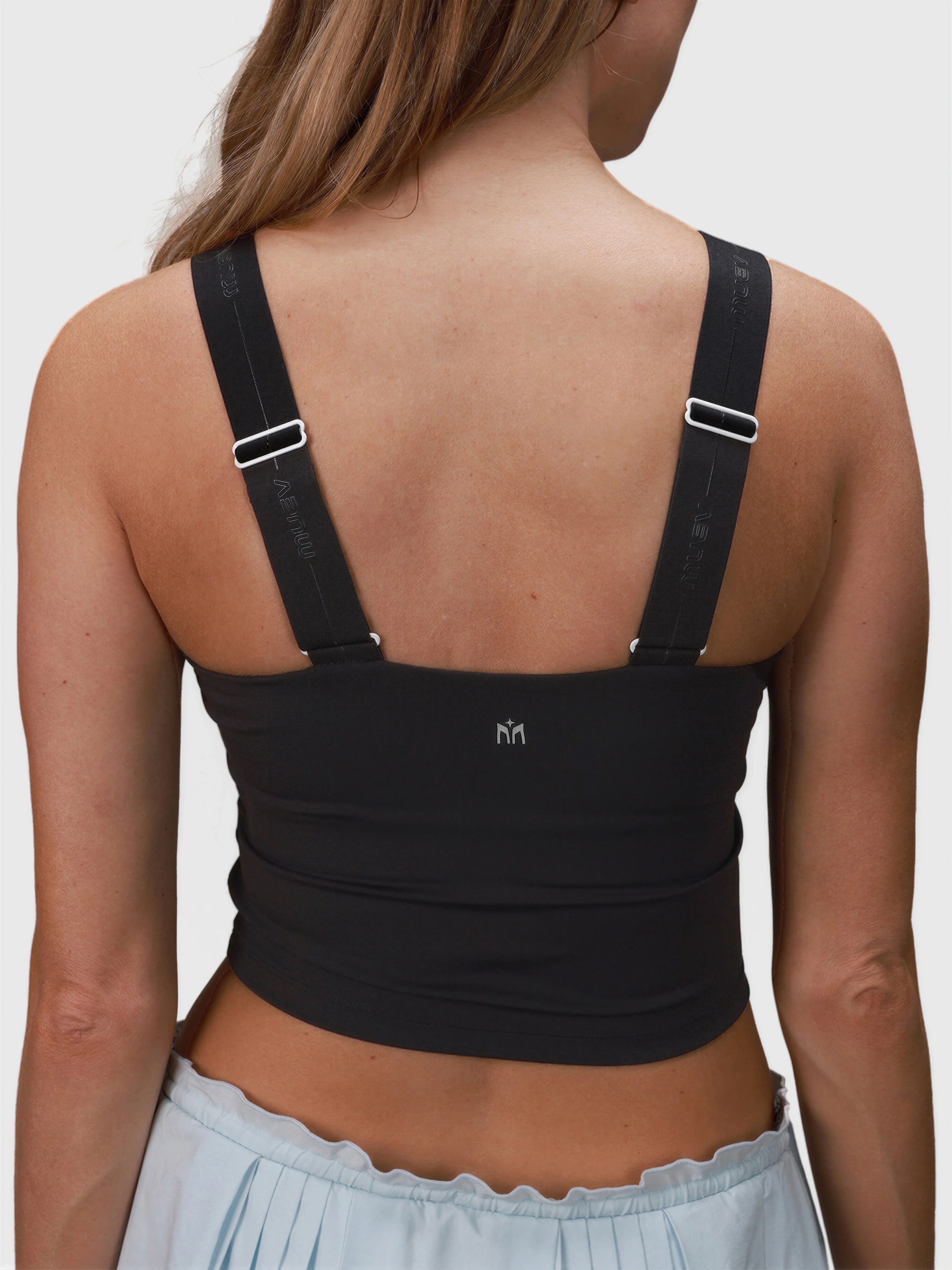 Back view of woman wearing black Airy Twist Tank by MUEV with adjustable straps for padel and pickleball apparel