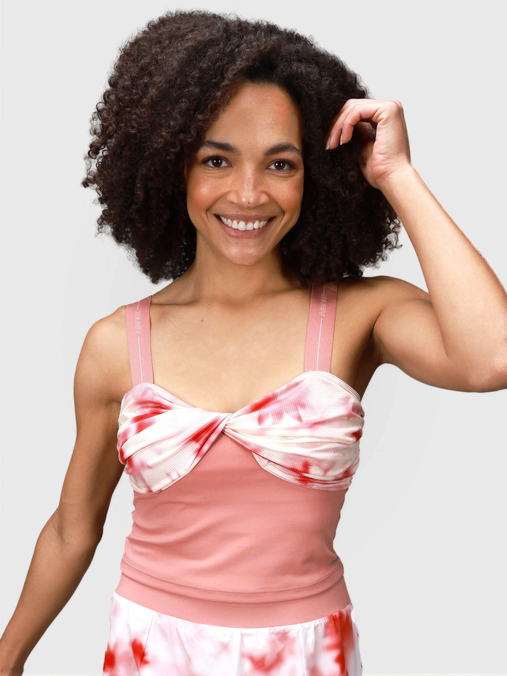 Woman wearing pink petal Airy Twist Tank by MUEV designed for padel and pickleball clothing