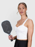 Woman wearing white Airy Twist Tank by MUEV holding a pickleball paddle, styled for pickleball apparel