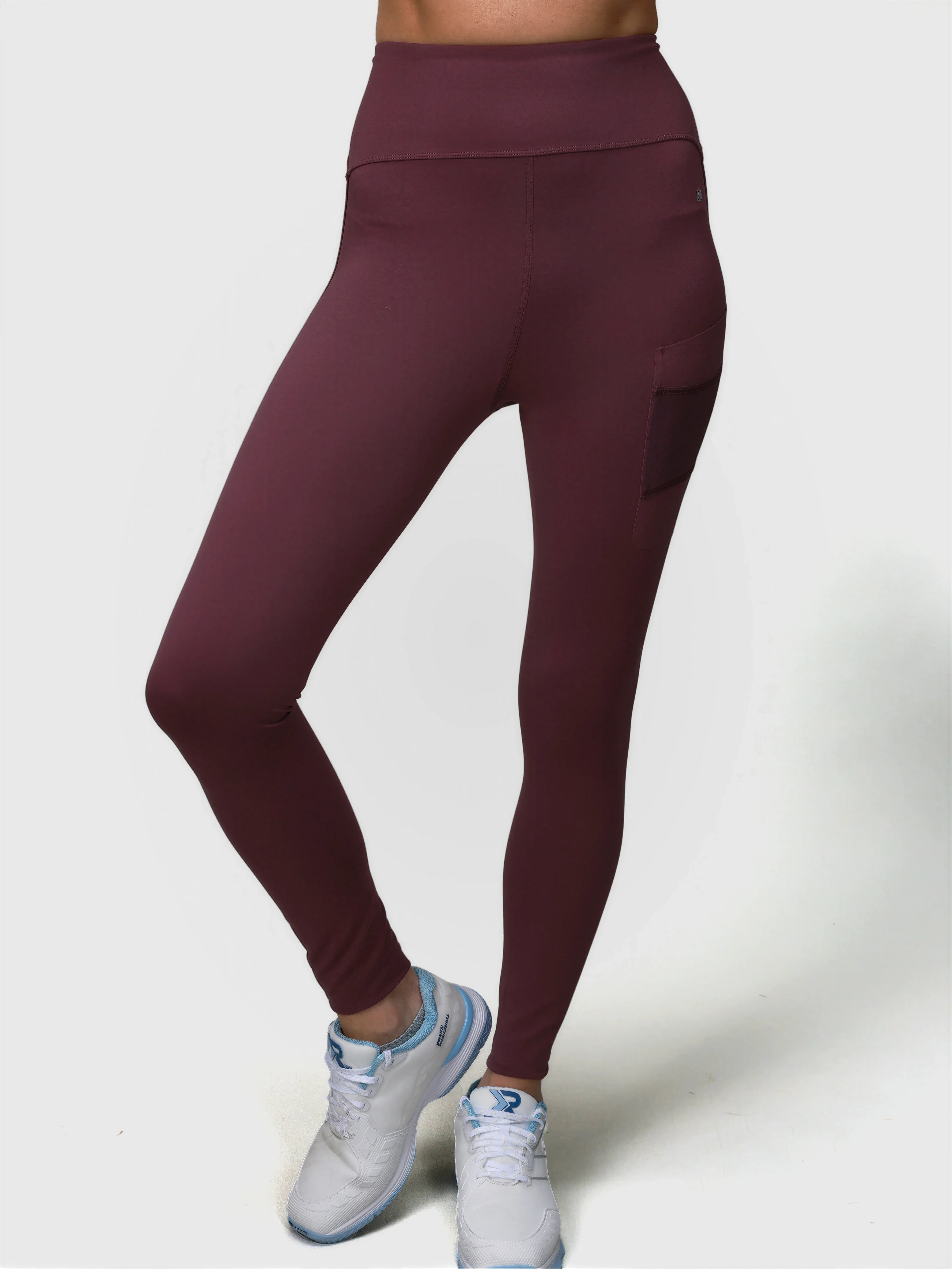 Woman wearing plum Court Legging by MUEV featuring side pocket, styled for padel and pickleball apparel