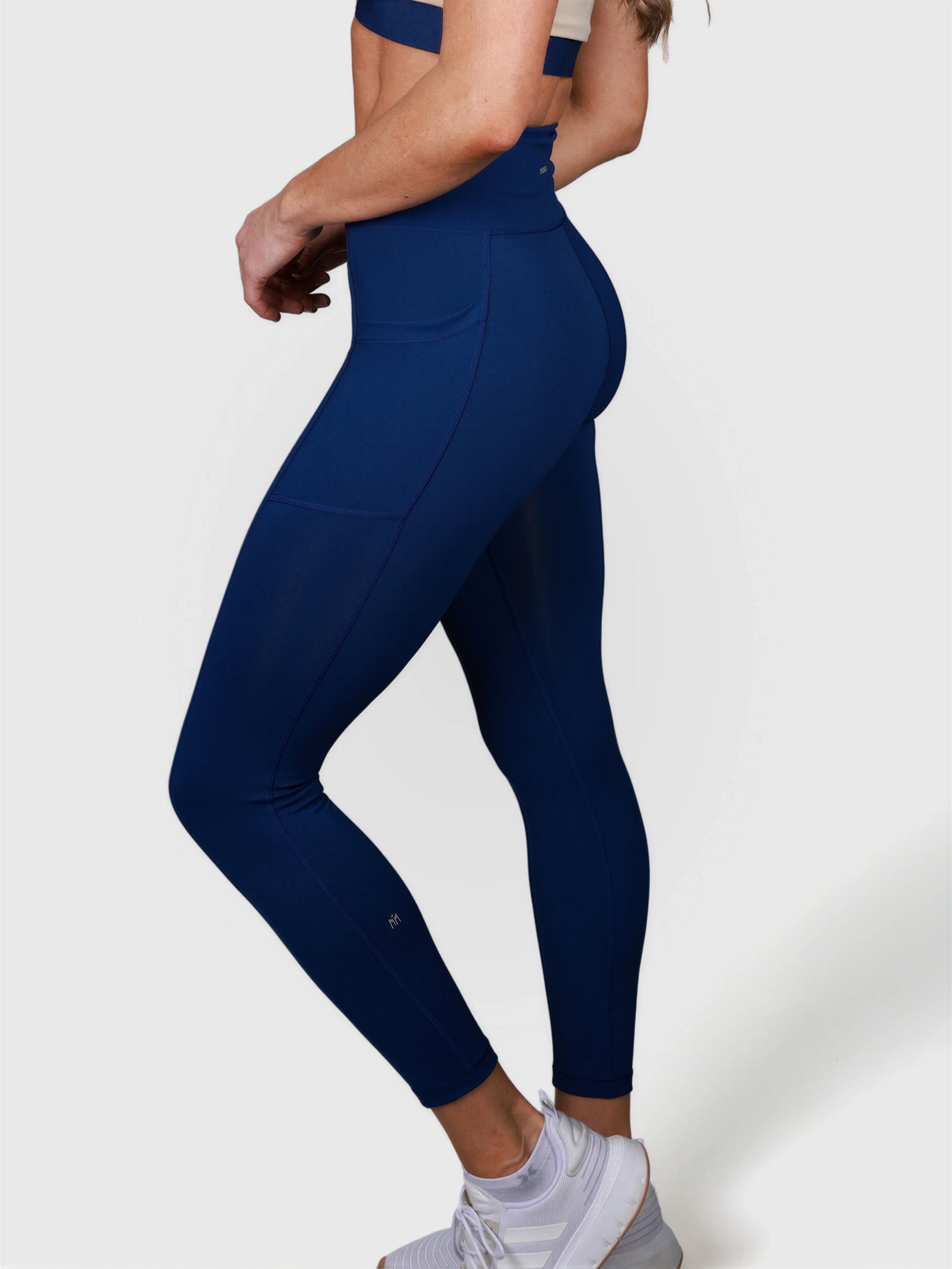 side profile of woman wearing navy V Cross Over Leggings by MUEV for padel and pickleball apparel