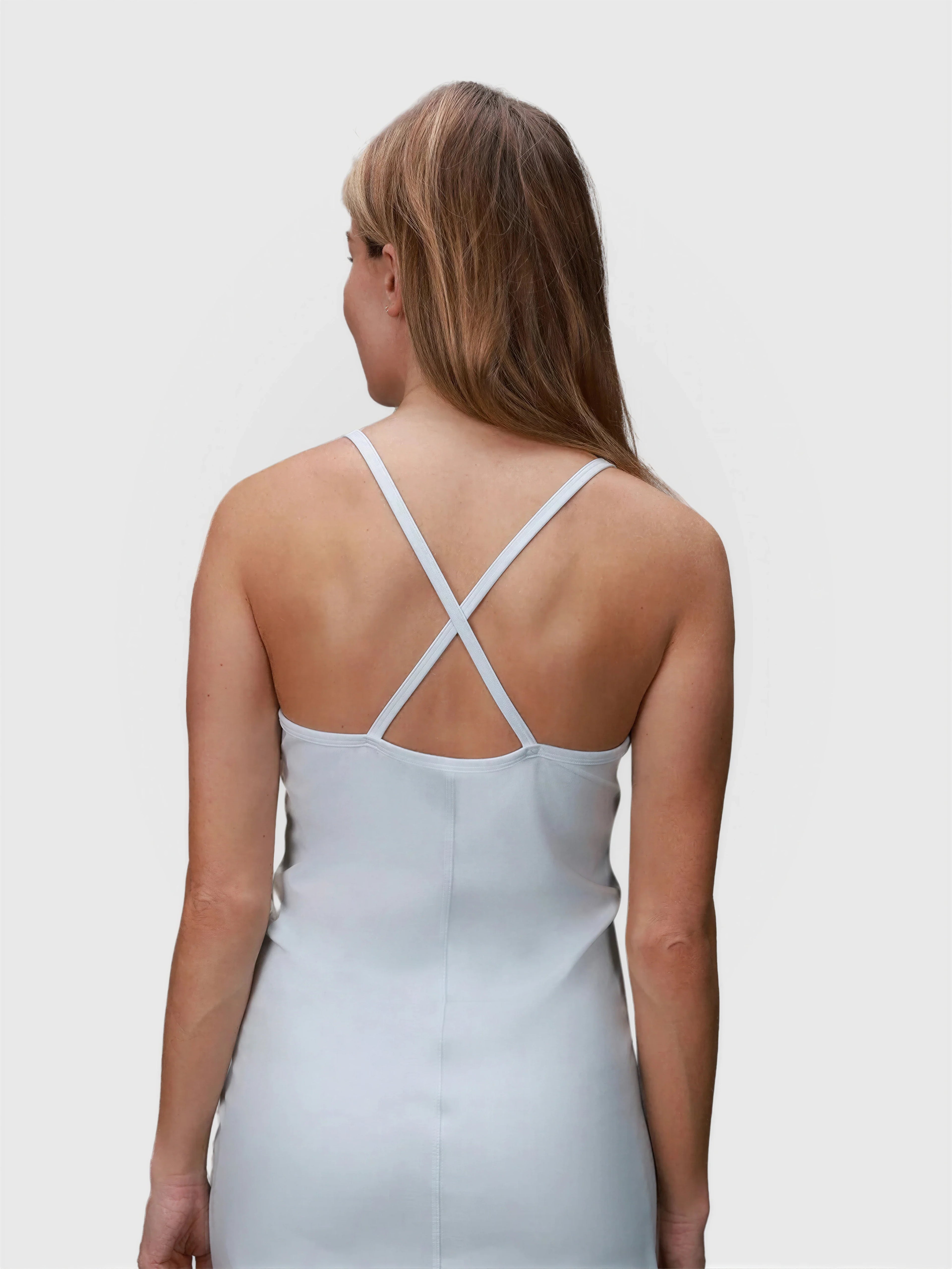 Rear view of ice blue Double V Dress by MUEV with crossed slim straps designed for padel and pickleball apparel