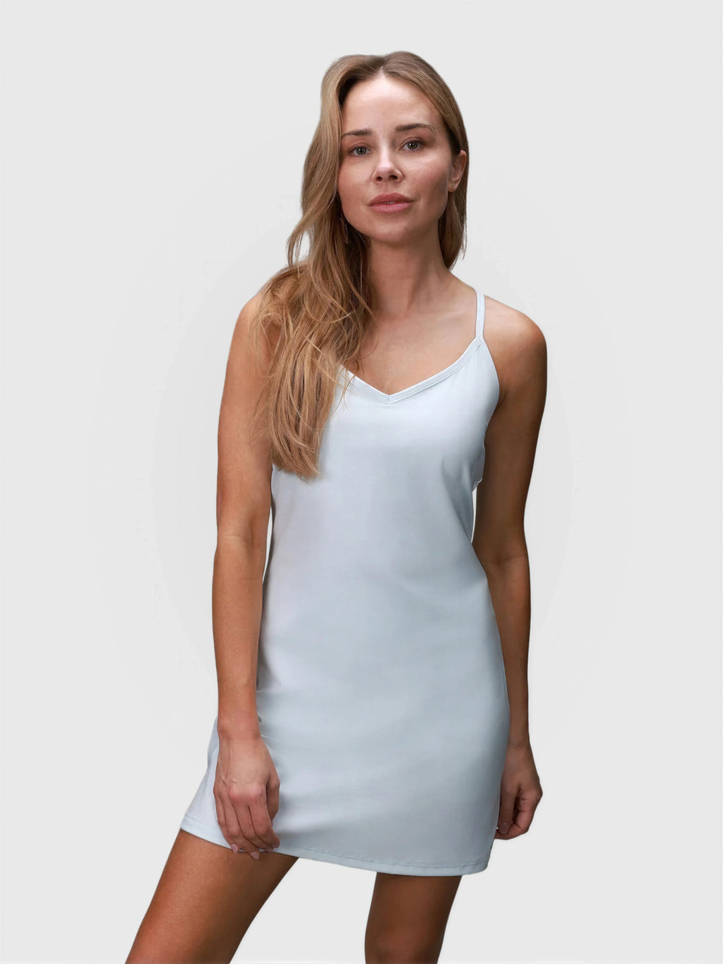 Woman wearing ice blue Double V Dress by MUEV designed for padel and pickleball apparel with slim straps and v-neckline