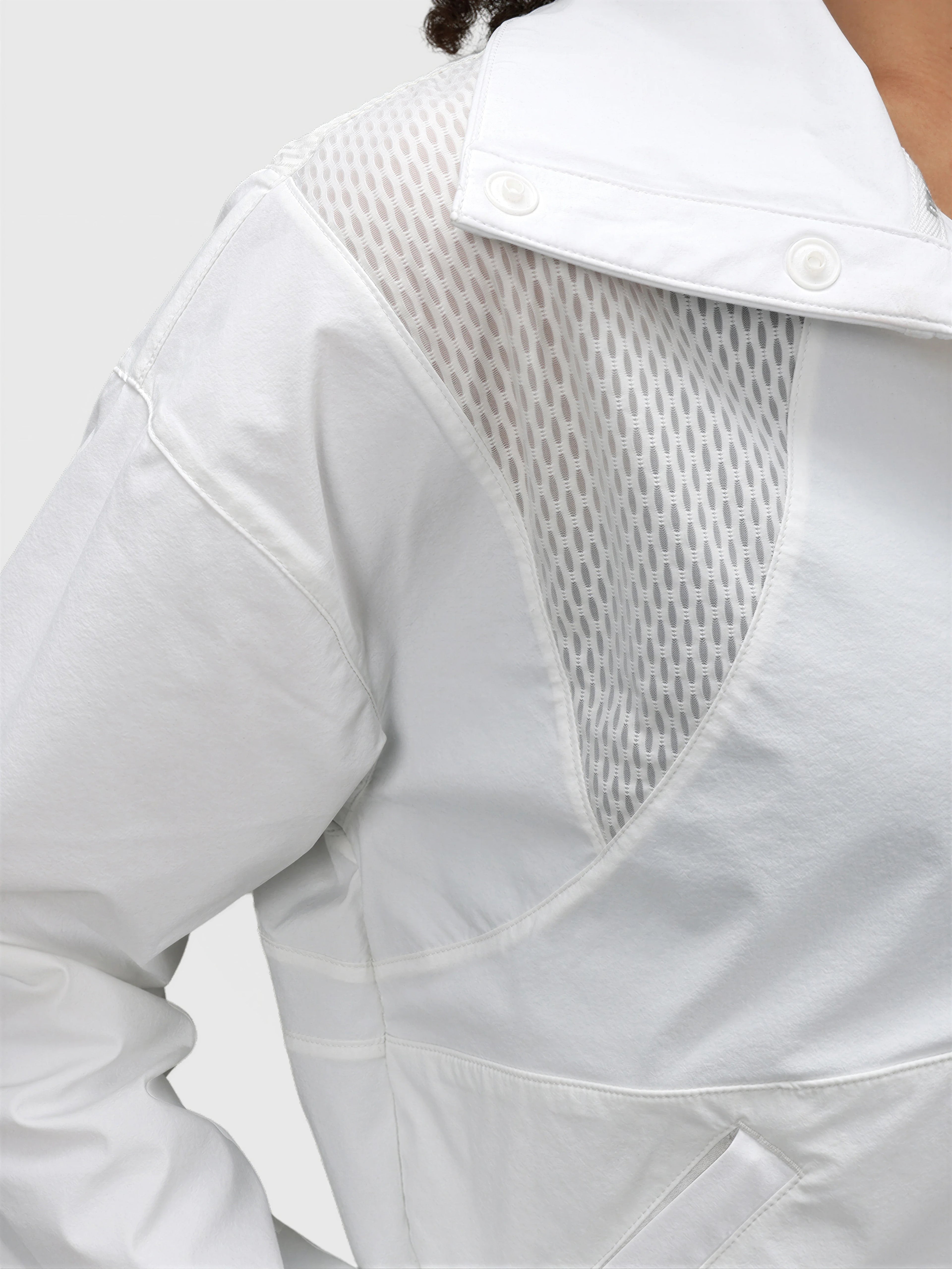 Close-up of white E Sas Crop Jacket by MUEV featuring breathable mesh panels for padel and pickleball apparel