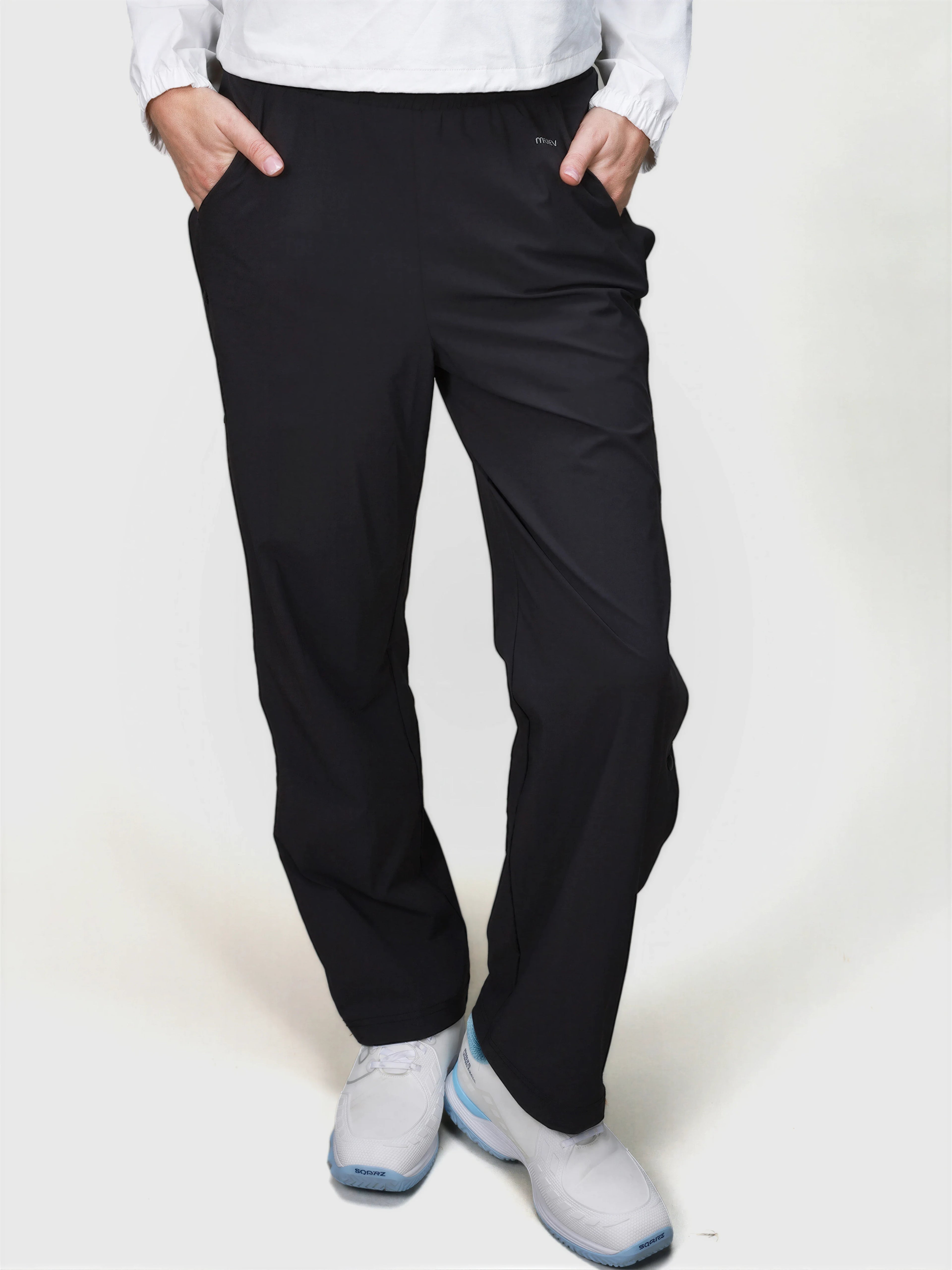 Front view of person wearing black E Sas Tear Away Pant by MUEV designed for padel and pickleball apparel with elastic waistband