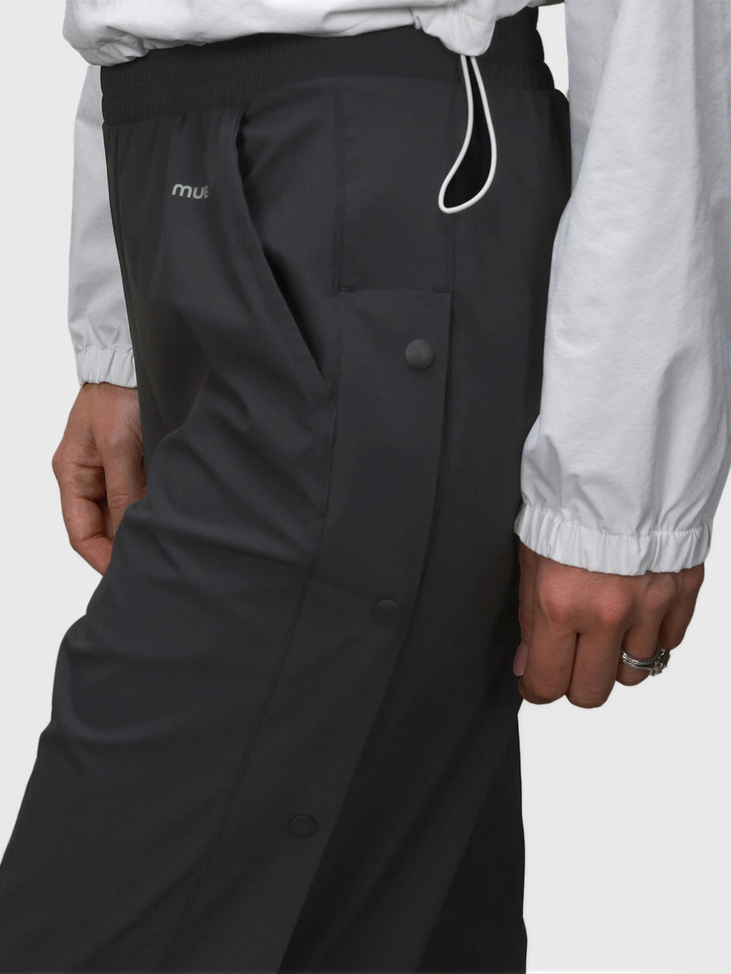 Close-up of black E Sas Tear Away Pant by MUEV with snap buttons and elastic waistband for padel and pickleball apparel