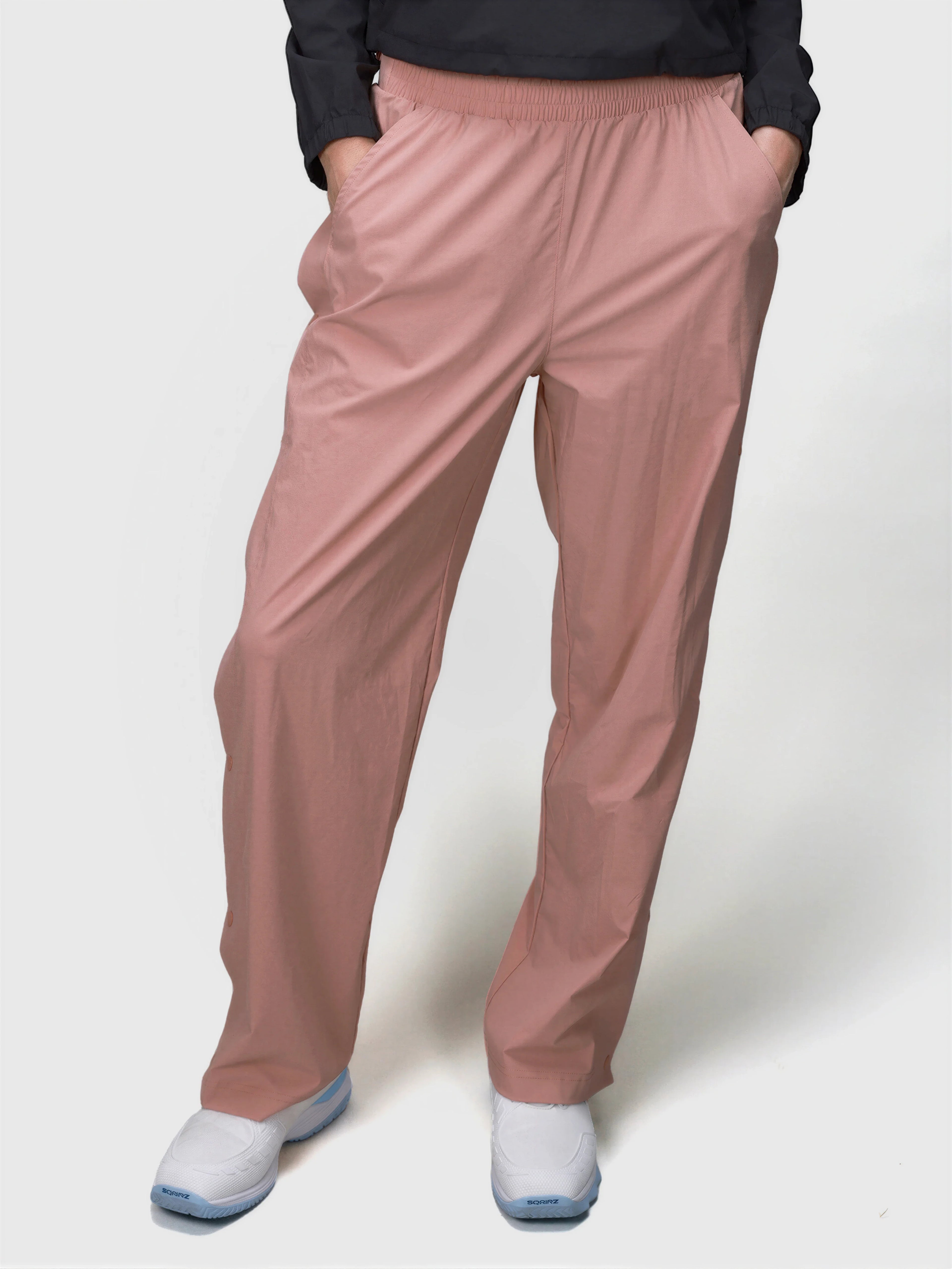 Front view of person wearing dusty pink E Sas Tear Away Pant by MUEV for pickleball clothing with elastic waistband and relaxed fit