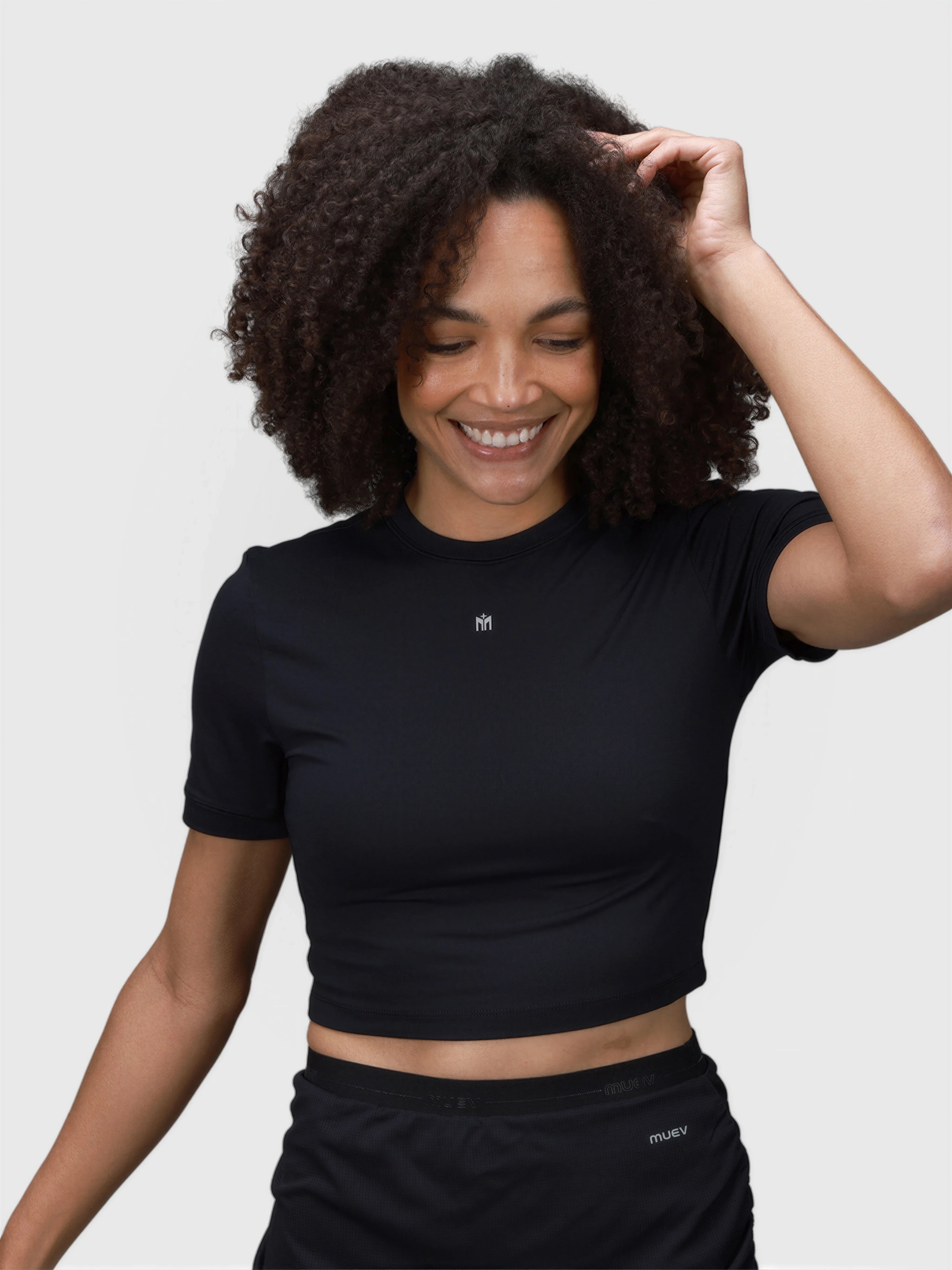 Woman smiling wearing black Kamryn Cropped Tee by MUEV designed for pickleball clothing with short sleeves and fitted style