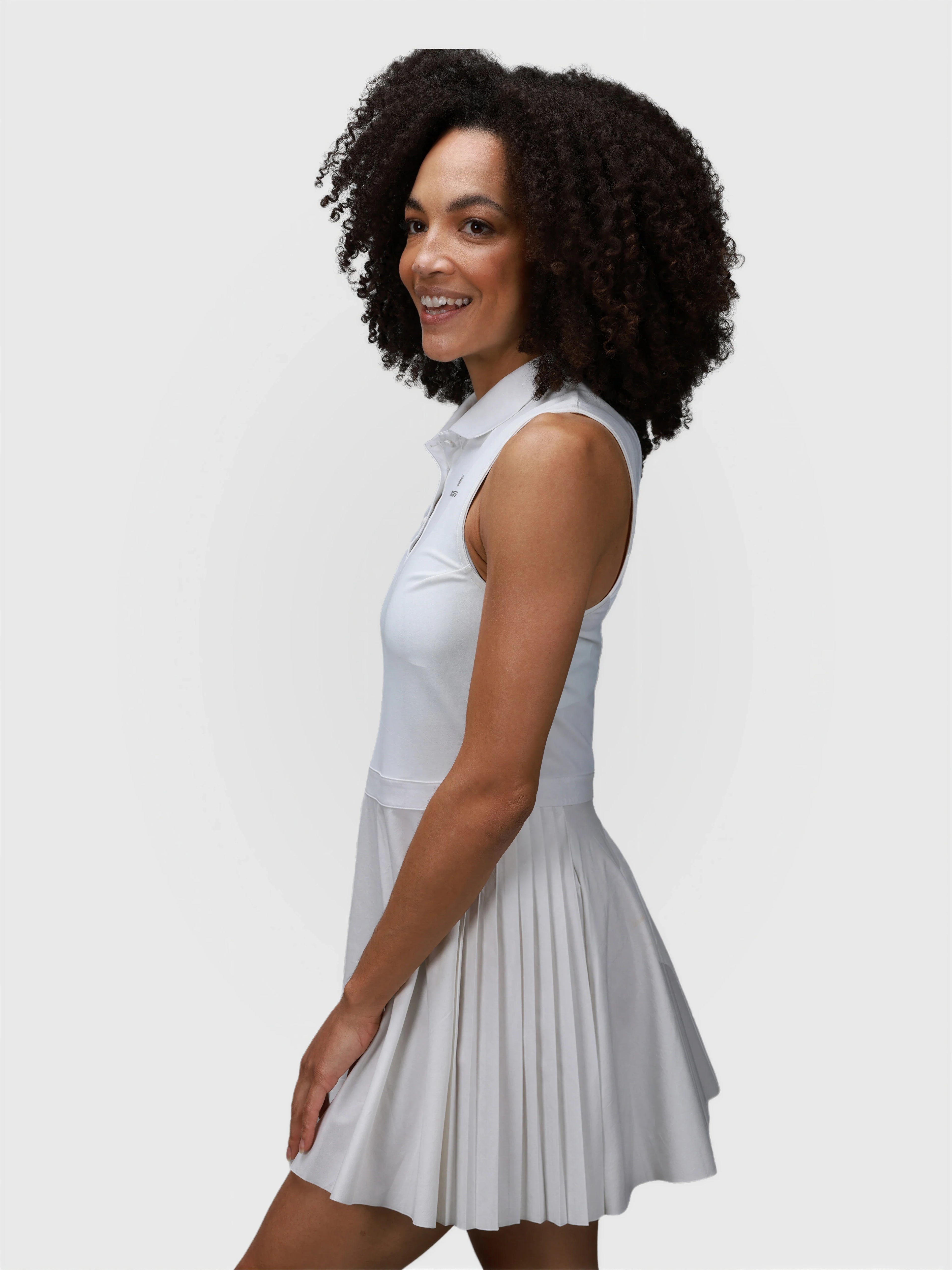 Side view of white Open Back Polo Dress by MUEV with sleeveless design and pleated skirt for pickleball apparel