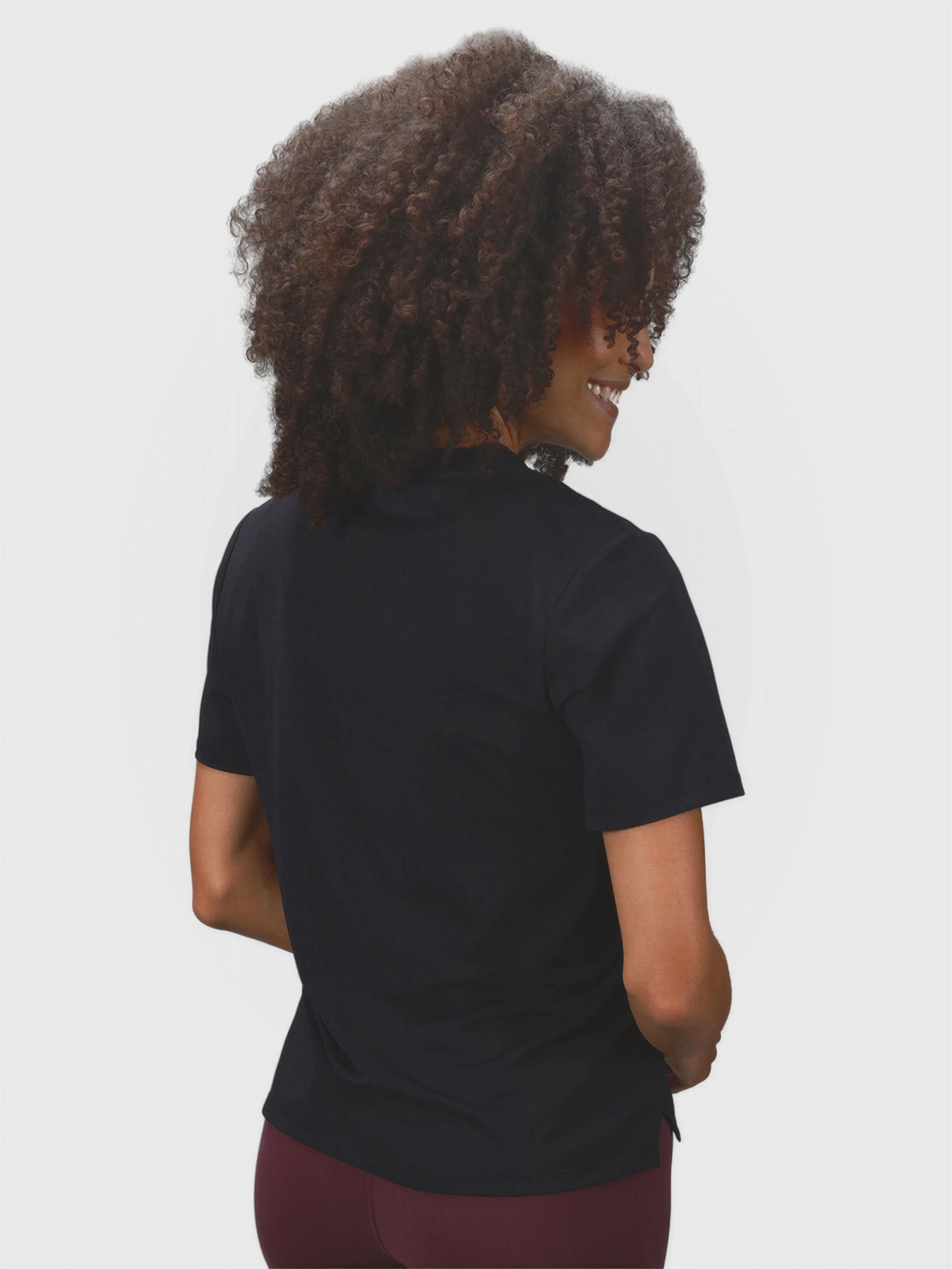 Back view of woman wearing black PowerMove Performance Tee by MUEV for padel and pickleball clothing