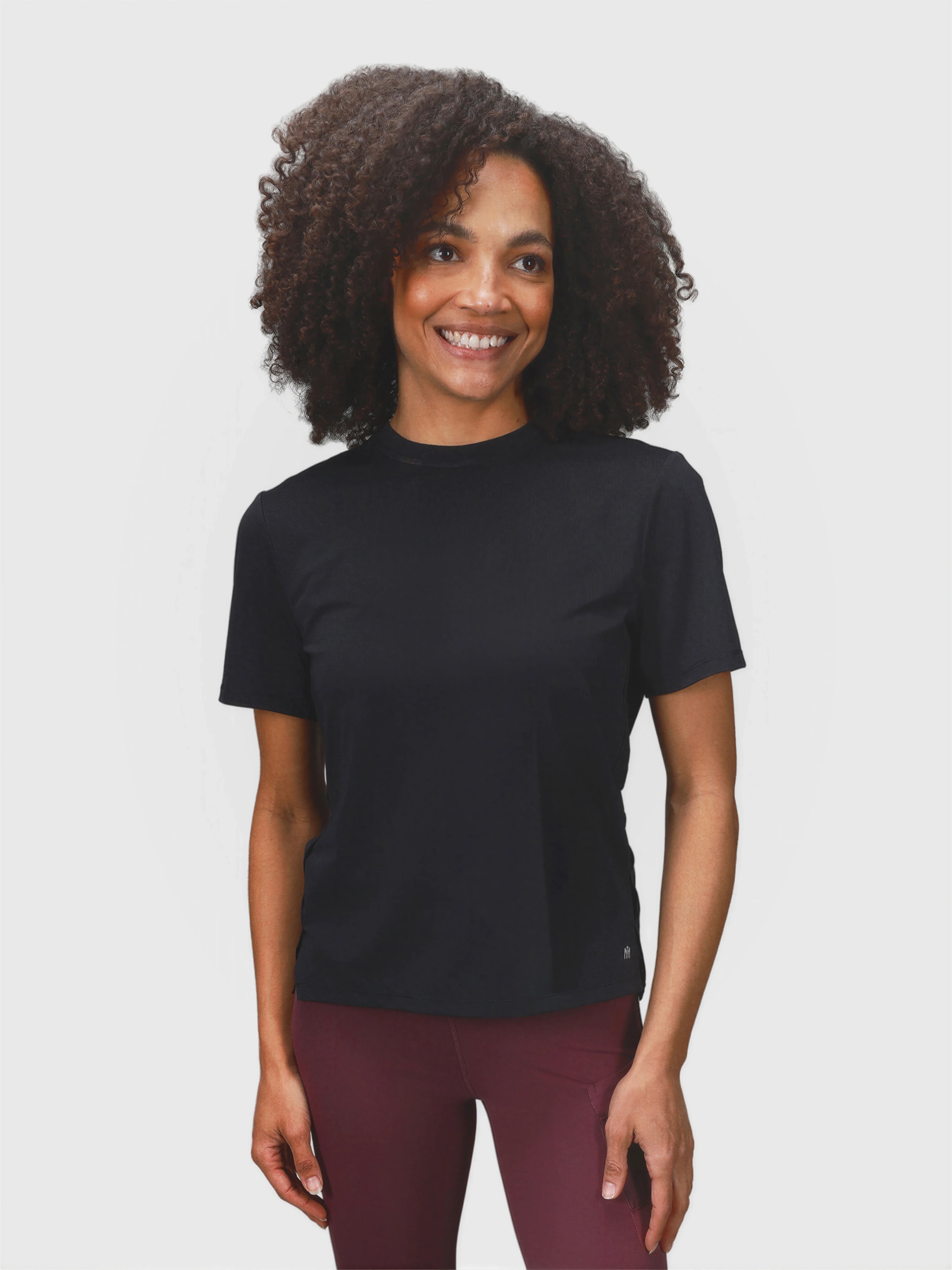 Woman wearing black PowerMove Performance Tee by MUEV styled for padel and pickleball apparel