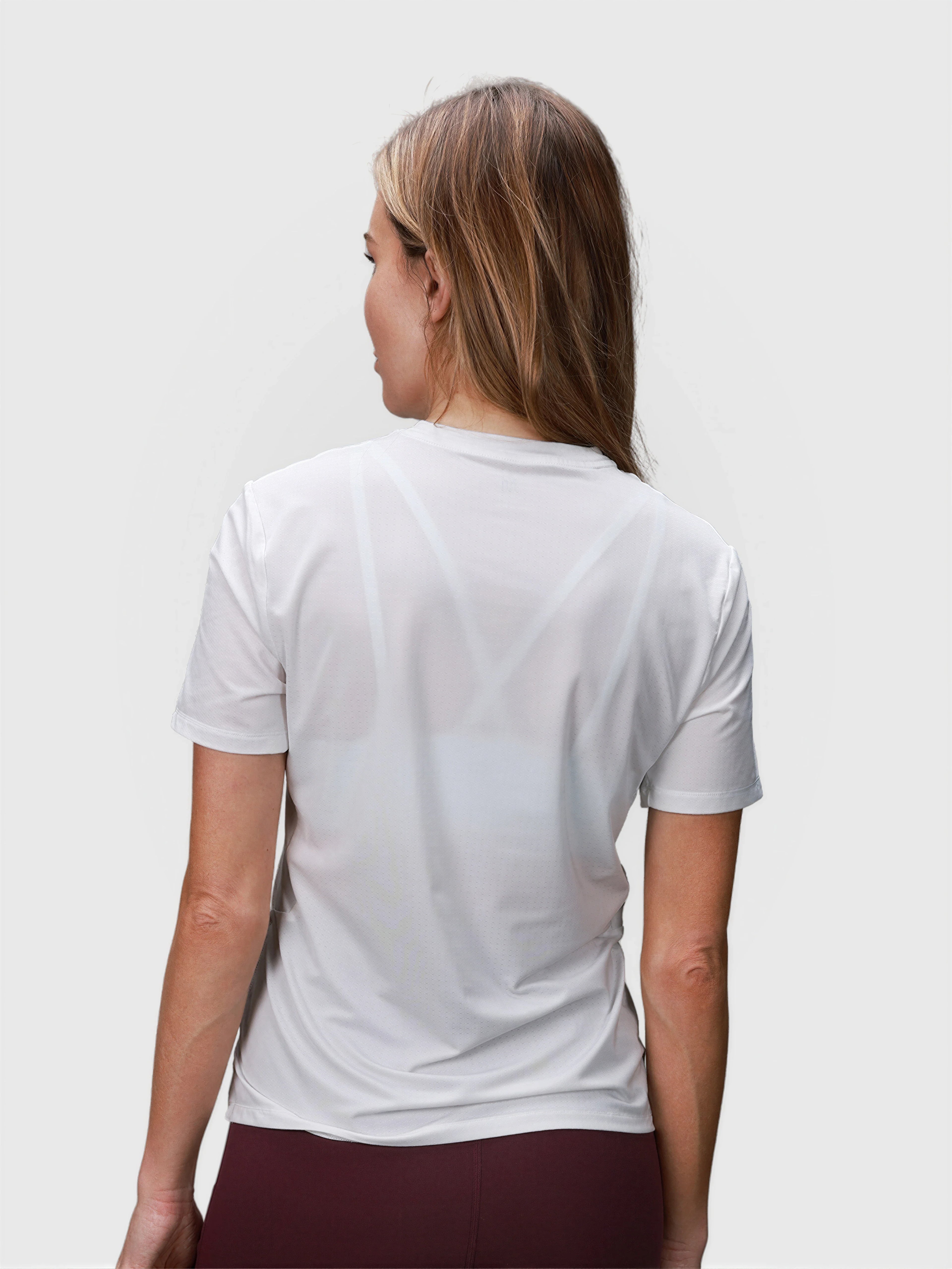 Back view of woman wearing white PowerMove Performance Tee by MUEV for padel and pickleball clothing