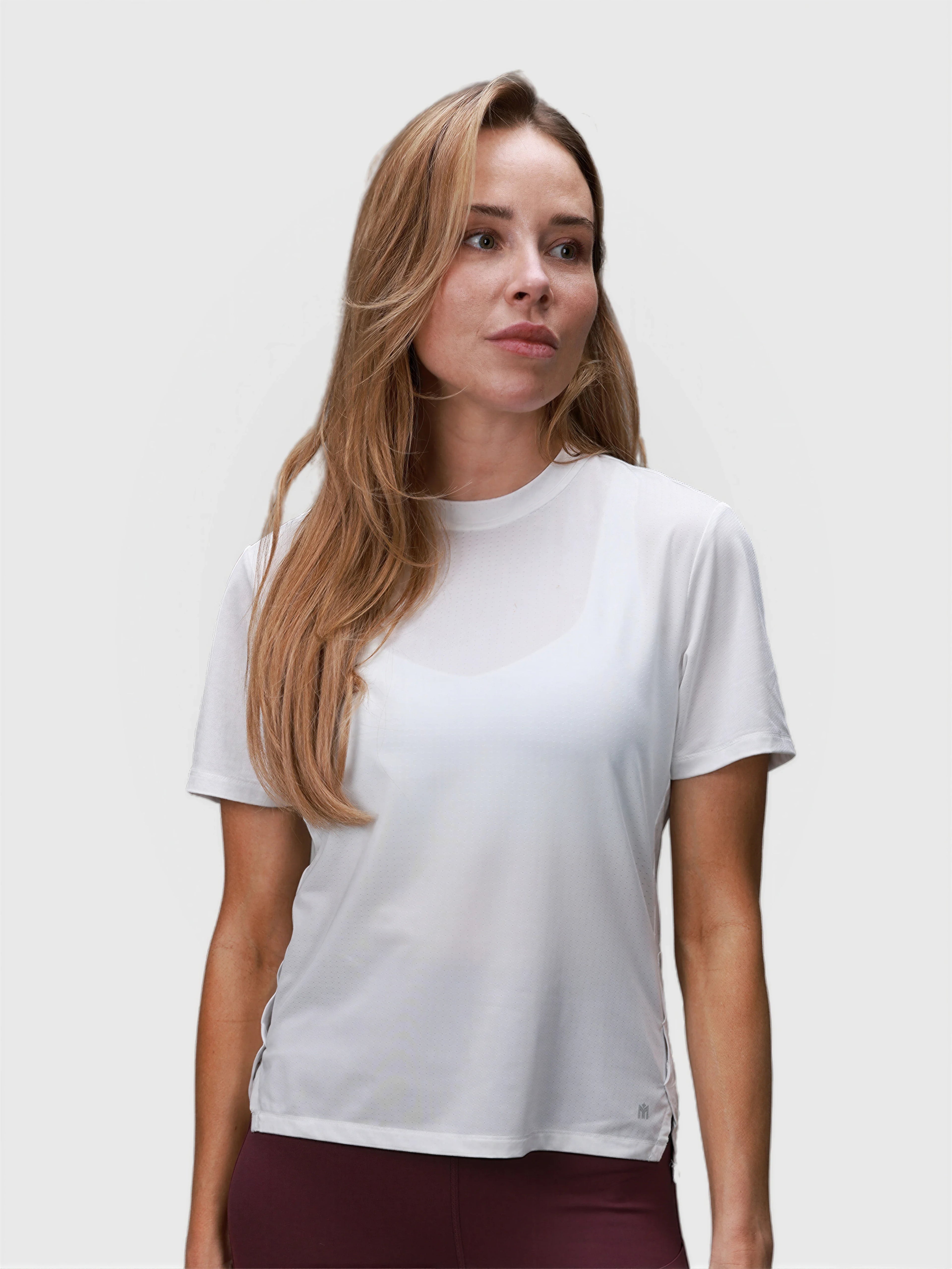 Woman wearing white PowerMove Performance Tee by MUEV designed for padel and pickleball apparel