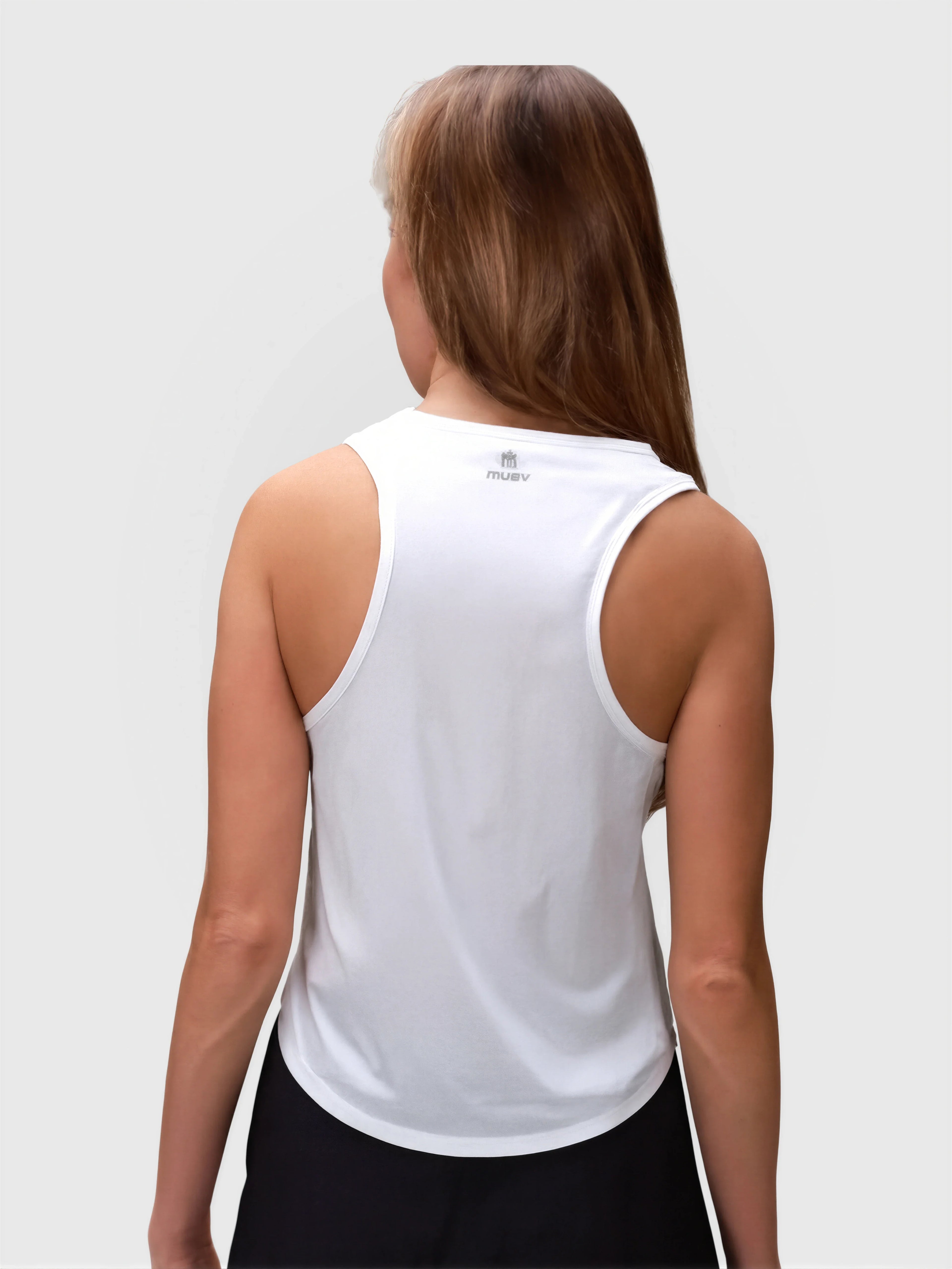 Woman shown from back wearing white Relaxed Tank by MUEV for padel and pickleball apparel