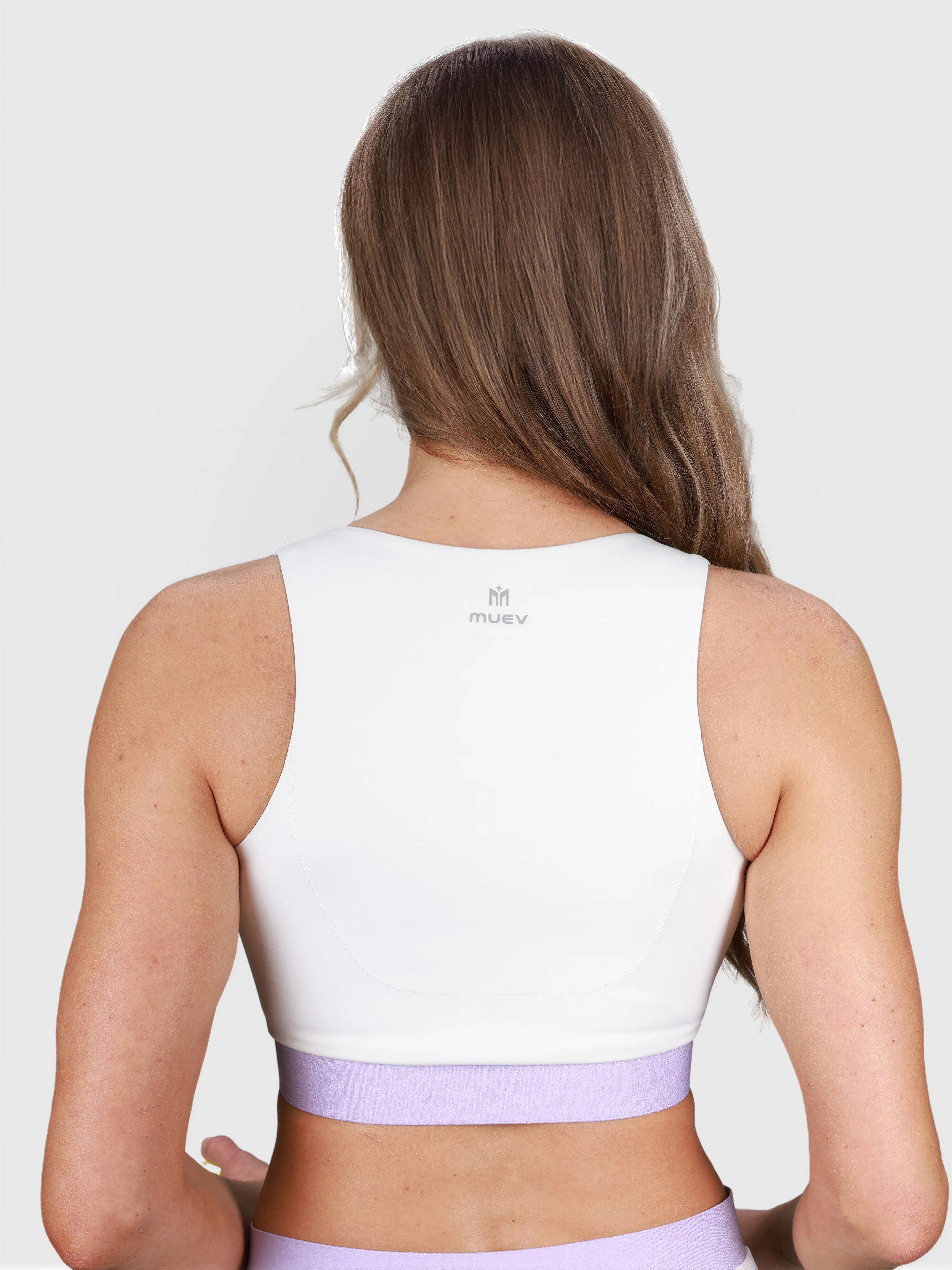 rear view of woman wearing white V Neck Tanklette Crop by MUEV for padel and pickleball clothing
