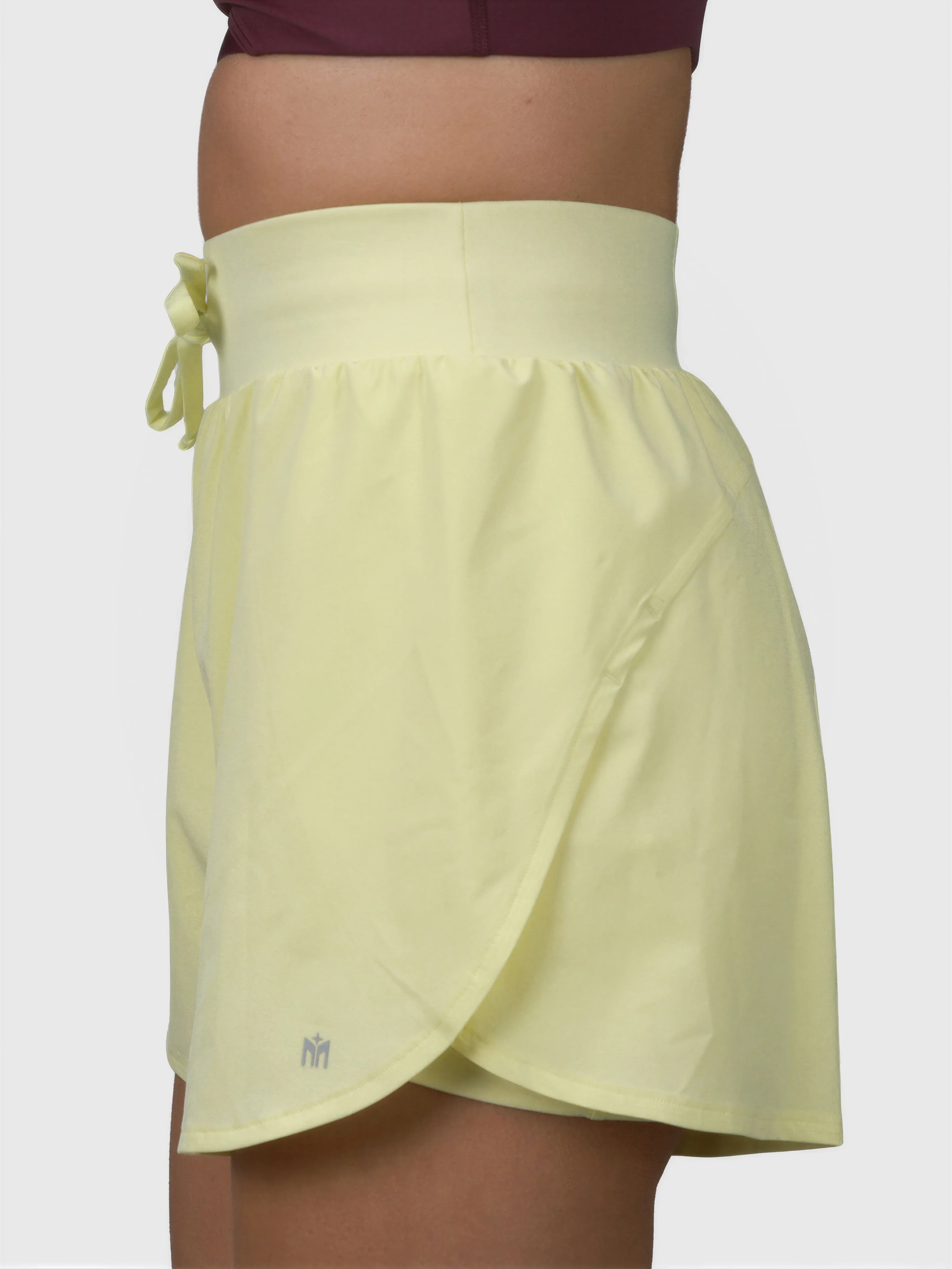 Side view of citron Tulip Compression Short by MUEV designed for pickleball and padel clothing