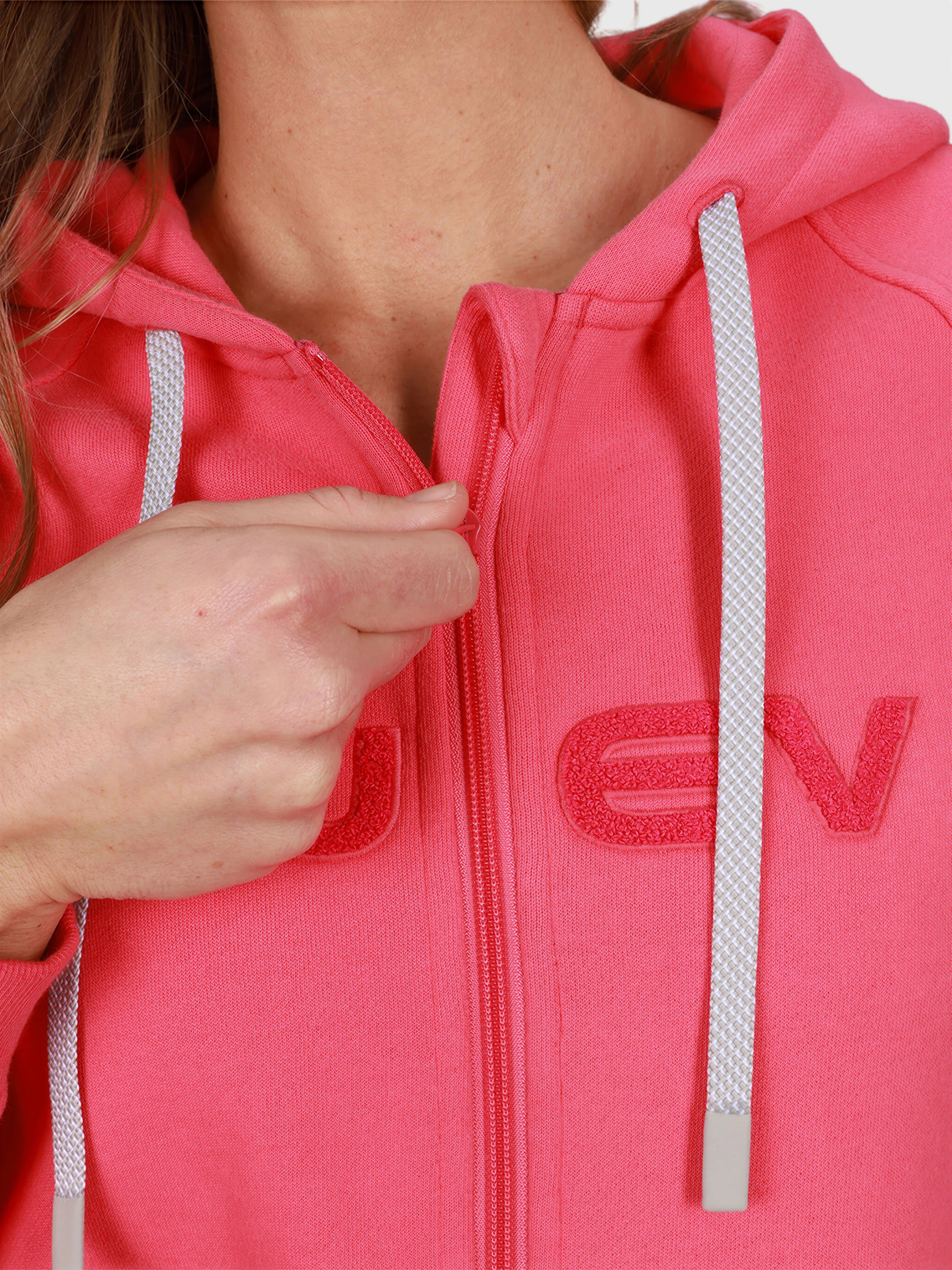 Close-up of woman zipping pink Women's Off Court Full Zip Hoodie by MUEV for padel and pickleball apparel